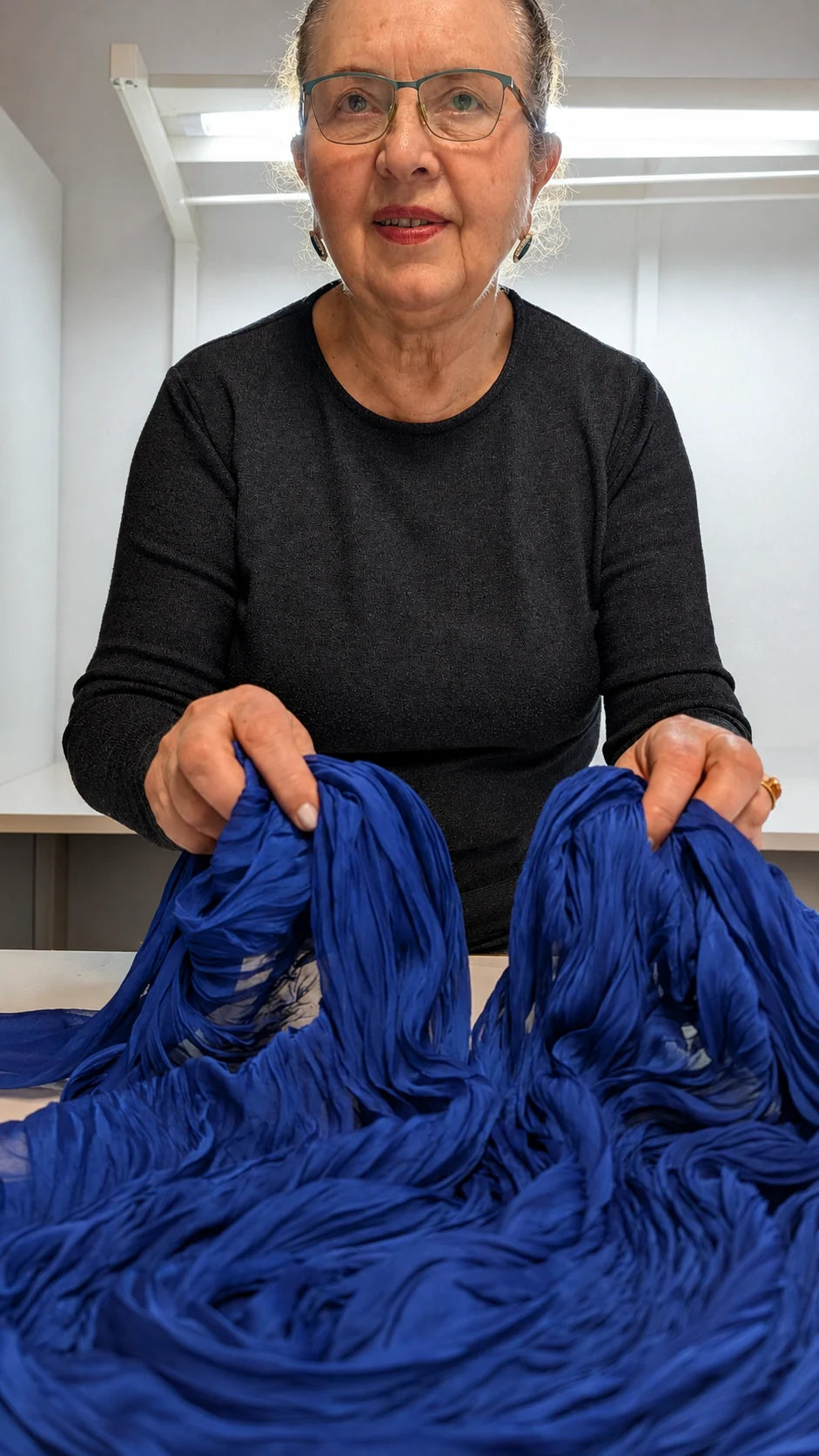 Stylyne's second-generation maker holding blue fabric in the Sofia atelier